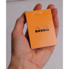 Rhodia Notizblock kopfseitig geheftet kariert (52 x 75mm) orangefarbener Einband